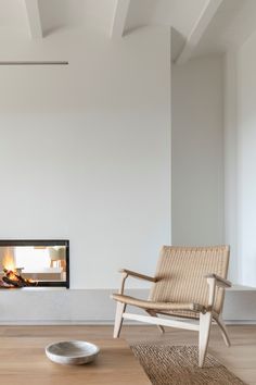 a living room with a fire place in the corner and a chair on the floor