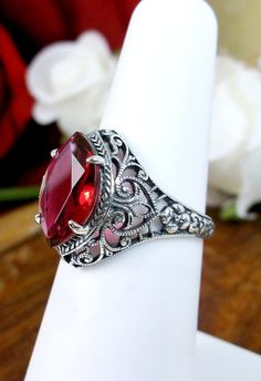 Simulated Red Ruby Ring Iris Design #201 Custom Made This is a stunning Art Deco/Edwardian reproduction in sterling silver filigree with a 4ct simulated ruby gemstone. The flawless gem is 13mm in long by 8mm wide. The ring is 16mm North to South on the finger. The inside of the band is marked 925 for sterling silver. Notice the beautiful craftsmanship of the silver filigree floral setting. This is an ornate and detailed ring. This is a lovely reproduction of an antique filigree ring, and it is r Antique Ruby Ring, Red Ruby Ring, Pink Peppermint, Natural Ruby Ring, Mushroom Jewelry, Antique Filigree, Detailed Ring, Gothic Beauty, Sterling Silver Filigree