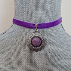 A lovely violet purple velvet ribbon is accented with a sliding pinch bail linked to an antique silver circular pendant with a set purple stone bead cabochon.  The ribbon is crimped with silver crimp bars with a matching chain for adjustable sizing from 13 " - 15". There is a wire wrapped violet crystal bead dangle linked on the chain.  The ribbon is 3/8" wide and there is a matching silver hook closure on the choker.  All of my jewelry items come boxed, and ribbon tied and tagged for easy gifting. Vintage Purple Round Pendant Jewelry, Purple Cabochon Round Pendant Jewelry, Vintage Adjustable Purple Jewelry, Adjustable Vintage Purple Jewelry, Adjustable Purple Pendant Jewelry, Adjustable Lavender Round Jewelry, Adjustable Round Lavender Jewelry, Adjustable Lavender Jewelry, Victorian Purple