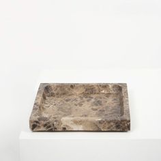 a marble tray sitting on top of a white pedestal