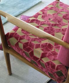 a wooden chair with a pink cushion on it