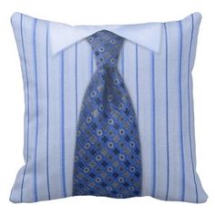 a blue and white striped pillow with a neck tie on it's side, against a white background