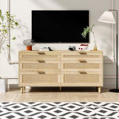 a living room with a large television mounted on the wall and a plant in front of it