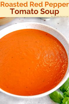 roasted red pepper tomato soup in a white bowl with basil on the side and text overlay that reads roasted red pepper tomato soup