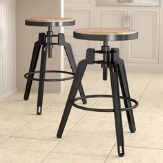 two stools in a kitchen with tile flooring and white walls, one is black and the other is light wood