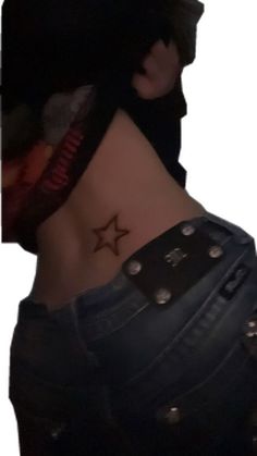 a woman with a star tattoo on her lower back and behind her head is a black hat