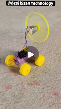 a small toy car with wires attached to it's wheels on the ground,