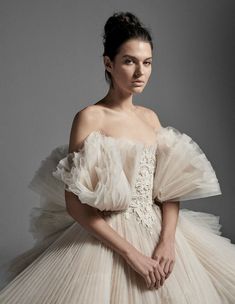 a woman in a white dress with ruffled sleeves and an off - the - shoulder top