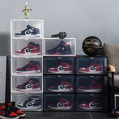 a stack of plastic boxes with various pairs of shoes on top of each one and a basketball ball in the middle