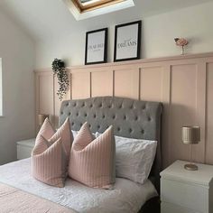 there is a bed with pink pillows and two pictures on the wall above it in this bedroom