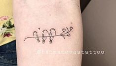 a small tattoo on the arm of a woman with birds sitting on a tree branch