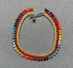 This beautiful beaded necklace is hand-woven by the women of the Embera Chami Indigenous Tribe of Colombia Handwoven Beaded Bracelets With Round Beads, Hand-strung Beaded Necklaces For Festivals, Hand-strung Round Beads Choker For Festival, Hand-strung Choker With Round Beads For Festival, Festival Choker With Hand-strung Round Beads, Artisan Handwoven Choker With Round Beads, Adjustable Handwoven Beaded Necklaces For Festivals, Traditional Adjustable Choker With Tiny Beads, Handwoven Round Beads Choker For Festivals