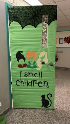 a green door decorated with black and white images, saying i smell children on it