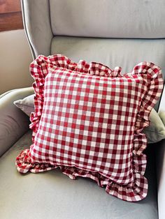 a red and white checkered pillow sitting on top of a chair