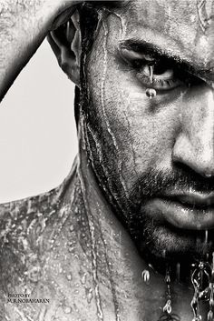 black and white photograph of a man with water on his face