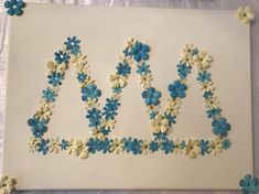 a cake with blue and white frosting that says love spelled out in the shape of flowers