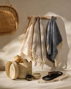 three towels hanging on a wall next to a cell phone and other items in a basket