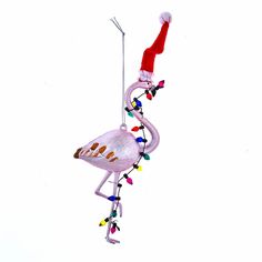 a pink flamingo ornament hanging from a string with christmas lights on it