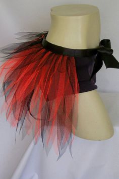 a white mannequin with red and black feathers on it's headband