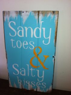 a wooden sign that says sandy toes and salty kisses