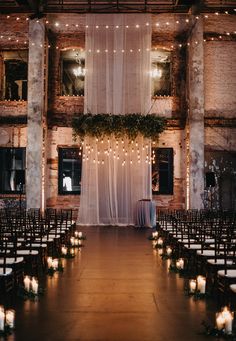 an indoor venue with rows of chairs and candles