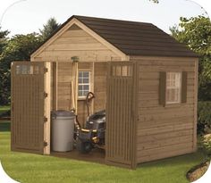 a wooden shed with a lawn mower in the yard