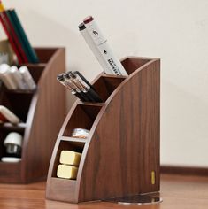 a wooden desk organizer with pens, pencils and other office supplies in the holder