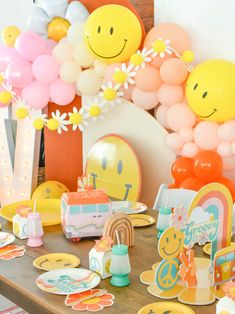 a table topped with lots of balloons and plates