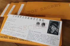 two yellow envelopes sitting on top of a wooden table next to an identification card