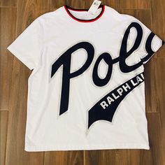 It’s A White T-Shirt With Polo Logo On It By Polo Ralph Lauren . It’s Brand New With Tags . Never Worn As Size Is Not Fit Cotton Logo Short Sleeve Tops, Short Sleeve Cotton Top With Logo, Cotton Logo Top With Short Sleeves, Sporty Cotton Tops With Logo, White Short Sleeve Top With Logo, White Cotton Top With Logo, Casual Short Sleeve Shirt With Logo, White Graphic Tee With Logo, Casual Short Sleeve Logo Top