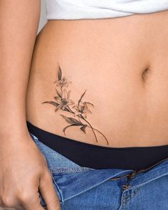 a woman's stomach with a flower tattoo on her belly and the bottom part of her stomach