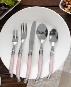 a white plate topped with silver and pink utensils