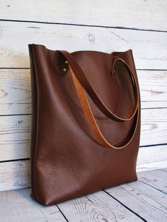 Stylish chocolate leather tote: perfect for use as a shopper or casual tote.  Made with a quality German bull hide. The leather is tough and durable and has been treated with a top-coat which preserves the original texture and marks/scars in the animals skin. Natural suede lining. Sturdy brown leather handles and antique-look rivets.  ***Dimensions***  Width/Height/Depth: 38(top)x36x8cm or 14x13.5x3 inches Straps: approx 65 cm  Please ask if you have any questions. Fall Bags With Single Shoulder Strap For Everyday Use, Fall Everyday Single Shoulder Strap Bag, Fall Leather Hobo Bag Shaped As Tote, Leather Hobo Tote Bag For Fall, Fall Hobo Bag With Leather Handles For Everyday, Leather Hobo Bag For Everyday Fall Use, Everyday Fall Hobo Bag With Leather Handles, Fall Soft Leather Hobo Bag For Everyday, Versatile Everyday Hobo Bag With Leather Lining