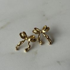 hammered textured bow earrings for the perfect coquette aesthetic material: 18k gold plated on brass length: 2.6cm width: 2cm Aesthetic Jewelry Earrings, Bow Earrings Aesthetic, Cute Jwellary Aesthetic, Girly Jewelry Aesthetic, Cute Accessories Aesthetic, Aesthetic Gold Earrings, Gold Jewellery Earrings, Cute Gold Earrings