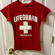 a red t - shirt with the words lifeguard on it hanging from a door