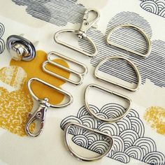 four pairs of scissors sitting next to each other on a piece of paper with yellow and white designs