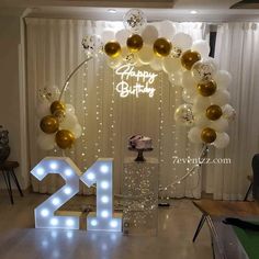 a birthday party with balloons, lights and a cake in the shape of number twenty