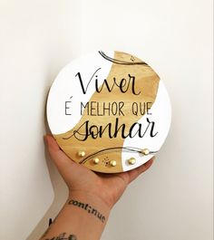 a person's hand holding a wooden plaque with writing on it that says, vier e melhora que jonar