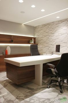 an office with a white desk and black chair in front of a stone brick wall