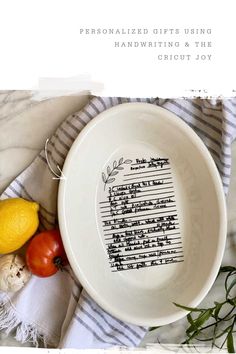 a white bowl with writing on it next to some vegetables and lemons in the background