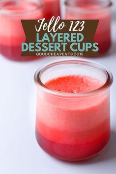 two jars filled with layered desserts on top of a white table next to each other