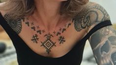 a woman with tattoos on her chest and arm