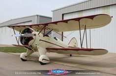 an old style airplane parked in front of a building