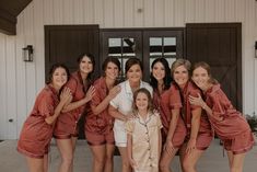 a group of women standing next to each other in front of a building with doors