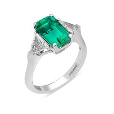 A thoughtful gift for the May birthday girl. This gorgeous birthstone ring showcases an elegant elongated cut natural green emerald wrapped in a four prong setting, poised prominently between two trillion shaped diamonds flowing seamlessly to a white gold band. Surprise your loved one with this exclusive, elegant, hand crafted dazzling designer jewelry piece. 
Available in all sizes, send us yours!
Zambia - a 3.26-carat Emerald-cut Green Emerald ring with triangle diamond side sto Trillion Ring, Crossover Diamond Ring, Emerald Earrings Drop, Triangle Diamond, Green Emerald Ring, May Birthday, Cushion Cut Ring, Orange Sapphire, White Gold Band