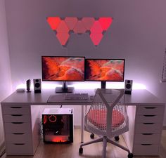 two computer monitors sitting on top of a desk