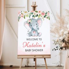 a welcome sign for a baby shower with an elephant on it and flowers in the background