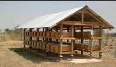 a small wooden structure sitting in the middle of a field