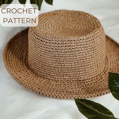 a close up of a straw hat on a bed with leaves and text that reads crochet pattern