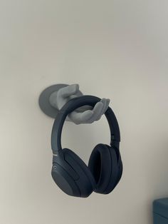 a pair of headphones hanging on the wall next to a blue box with an object in it